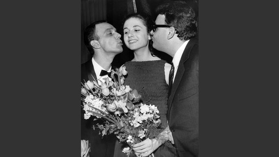 Gigliola Cinquetti beim Grand Prix d'Eurovision 1964 mit dem Texter Mario Panzeri und dem Dirigent Gianfranco Monaldi (links). © picture alliance / brandstaetter images/Votava 